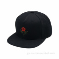 Caipín snapback dubh le bróidnéireacht bláthanna